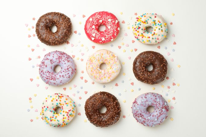 Flat lay with tasty donuts on plain background