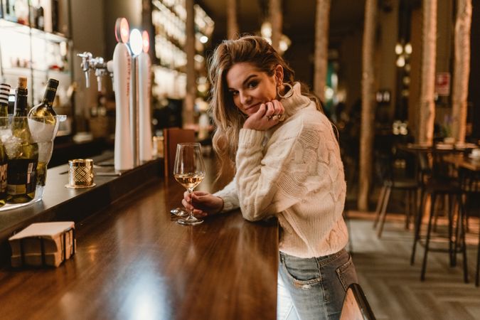Stylish woman drinking wine in bar