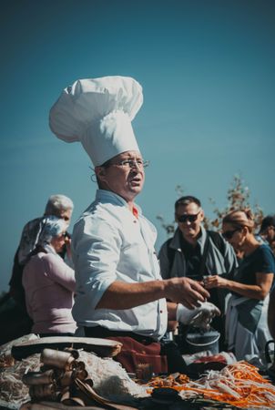 Man chef standing near food and people outdoor
