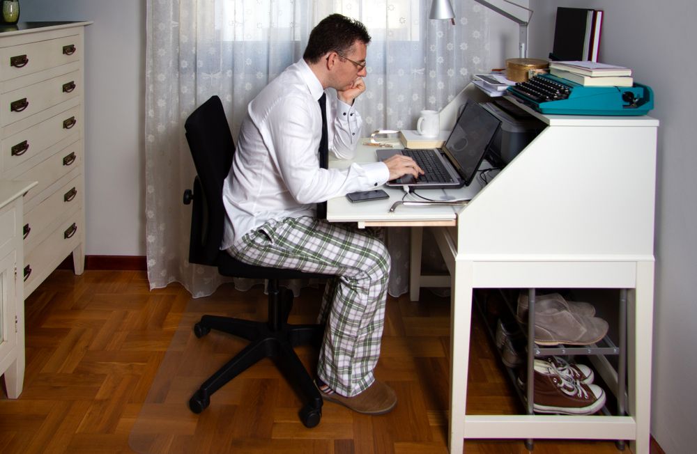 Man teleworking wearing shirt, tie and pajama pants