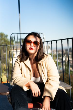 Cool young woman hanging out on the patio with sunglasses