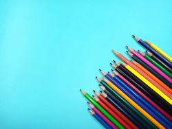 wooden color pencils arranged in bulk on a Light blue background