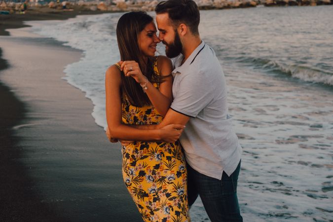 Loving couple embracing happily on sandy beach