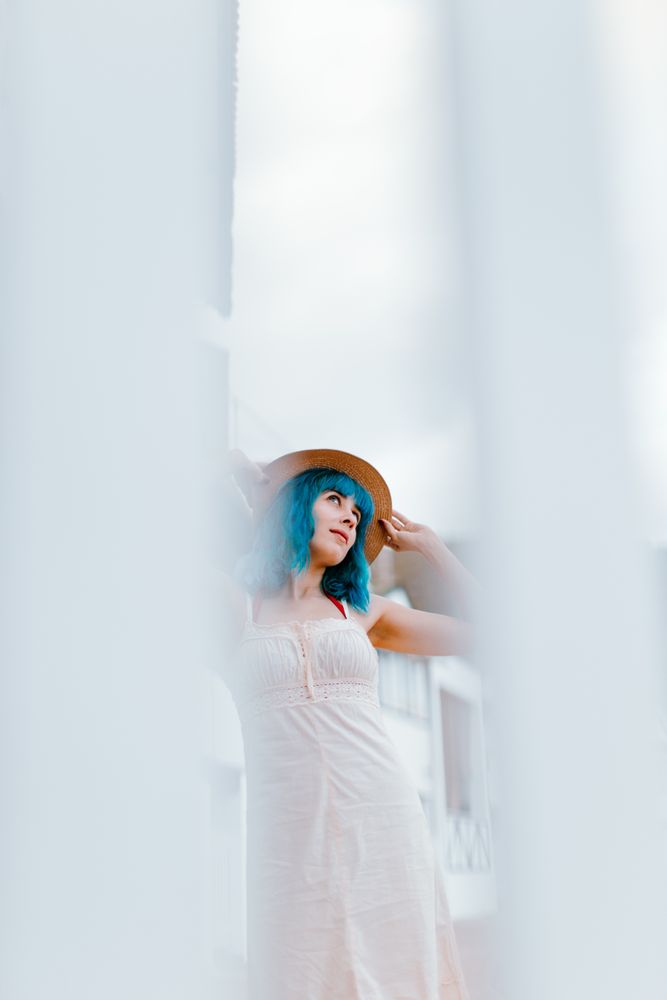 Carefree woman in sundress walking along sunny street