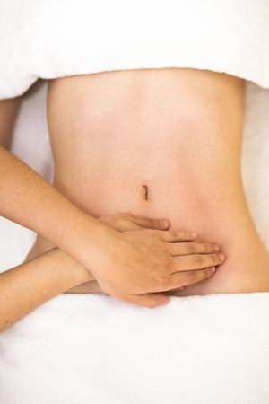 Top view of hands massaging female abdomen