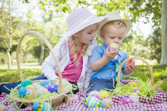 Cute Young Brother and Sister Enjoying Their Easter Eggs Outside