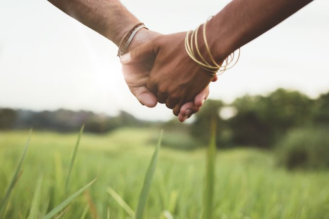 Man and woman hand in hand on meadow