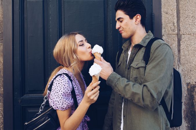 Happy couple feeding each other by ice cream