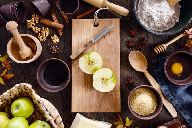 Ingredients for traditional apple pie on the textured brown wooden table, top view