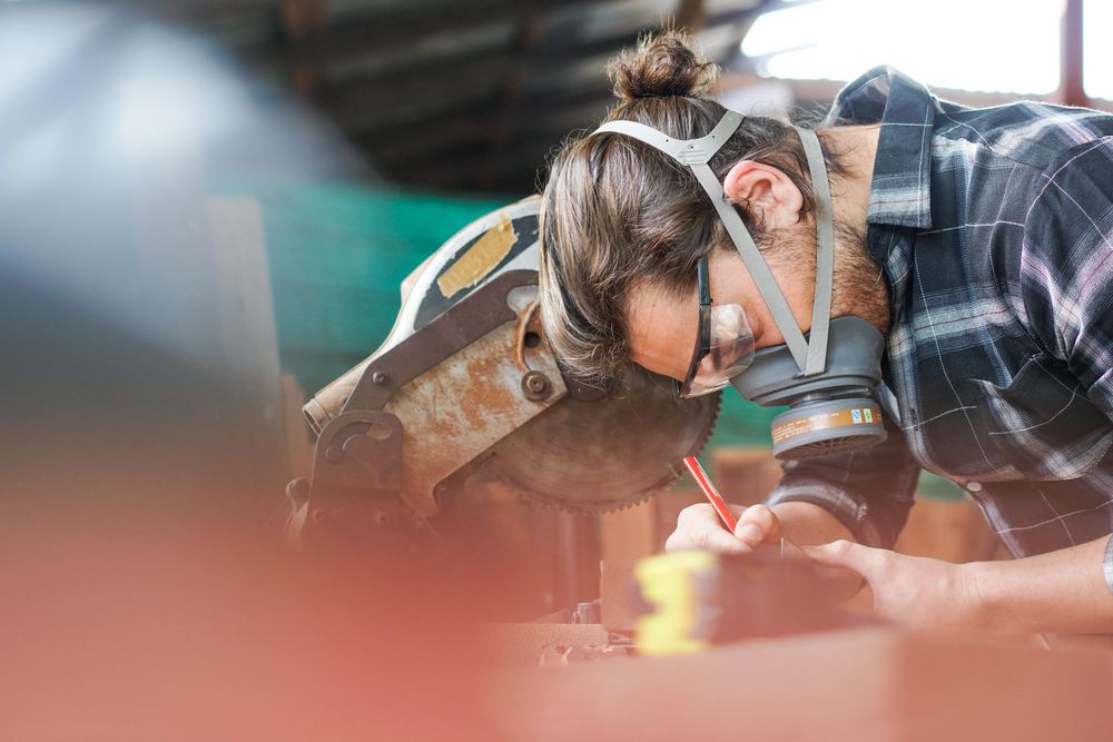 Carpenter working in shop with dust mask