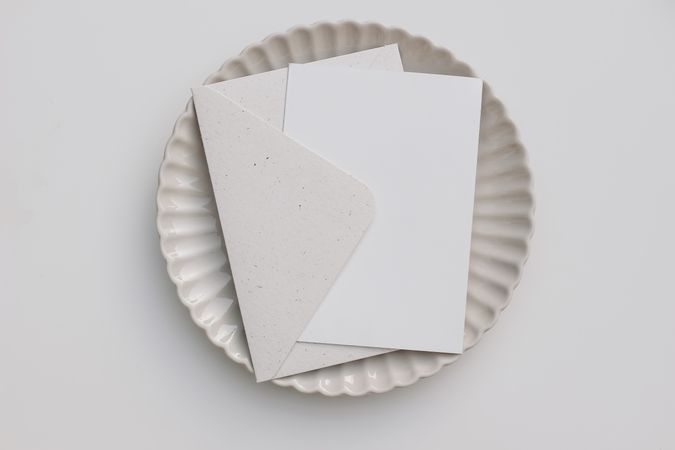 Mock up card in envelope in center of ceramic ridged plate