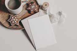 Christmas still life with card next to gingerbread cookies and coffee