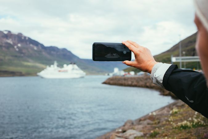 Woman with smart phone looking over cruise