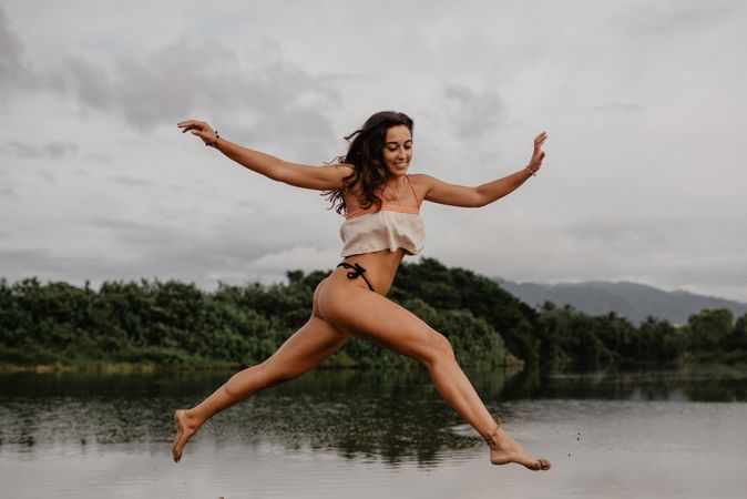 Smiling woman jumping over water