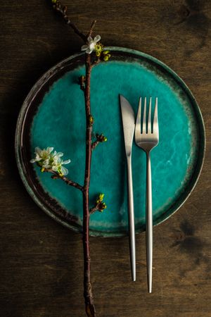 Spring table setting with cherry blossom on teal plate