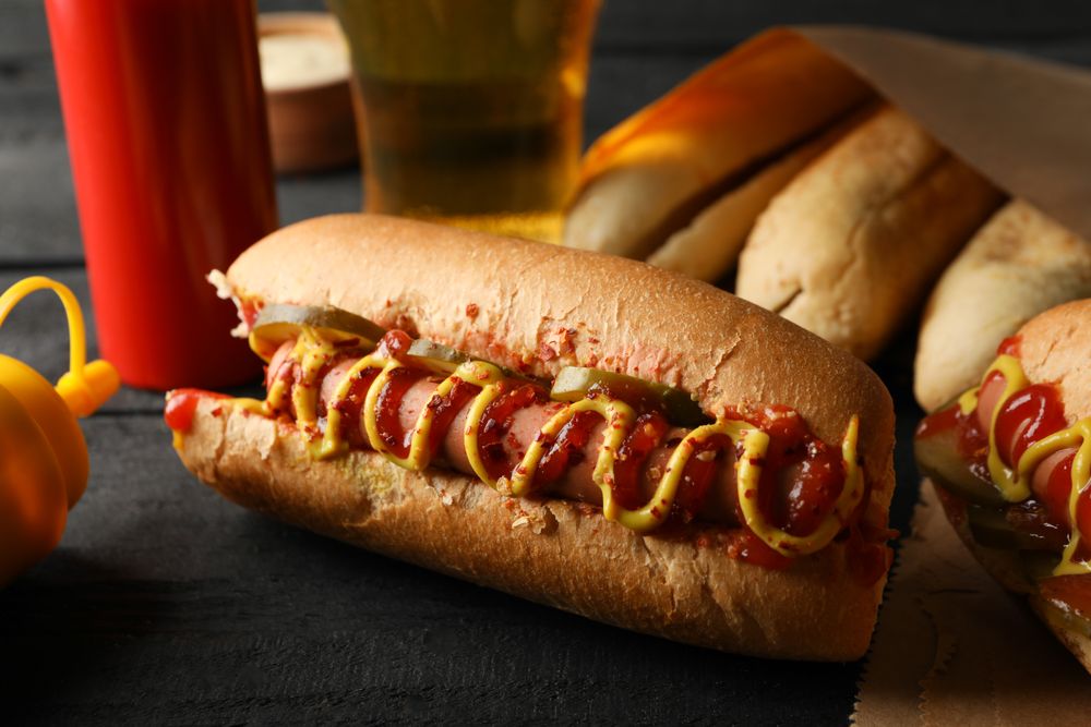 Composition with tasty hot dogs on wooden background