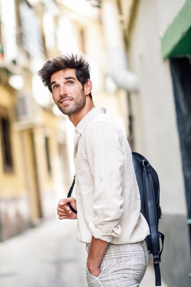 Curious man walking through the streets of Granada with backpack