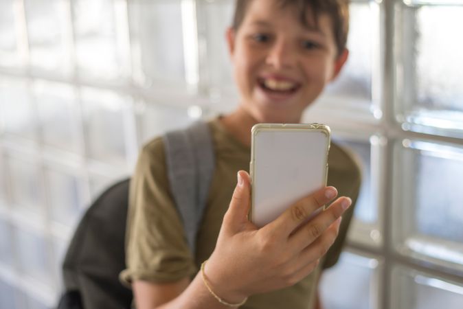 Smiling teenager looking at phone screen