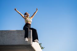 Woman sitting on corner of building roof