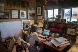 Farmer doing work at her computer in her farm office