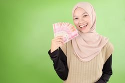 Happy Asian Muslim Woman Holding Rupiah