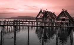 Thatched cottages suspended on stilts over lake