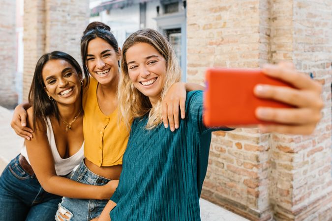 Cheerful women laughing and taking selfie together enjoying summer holidays