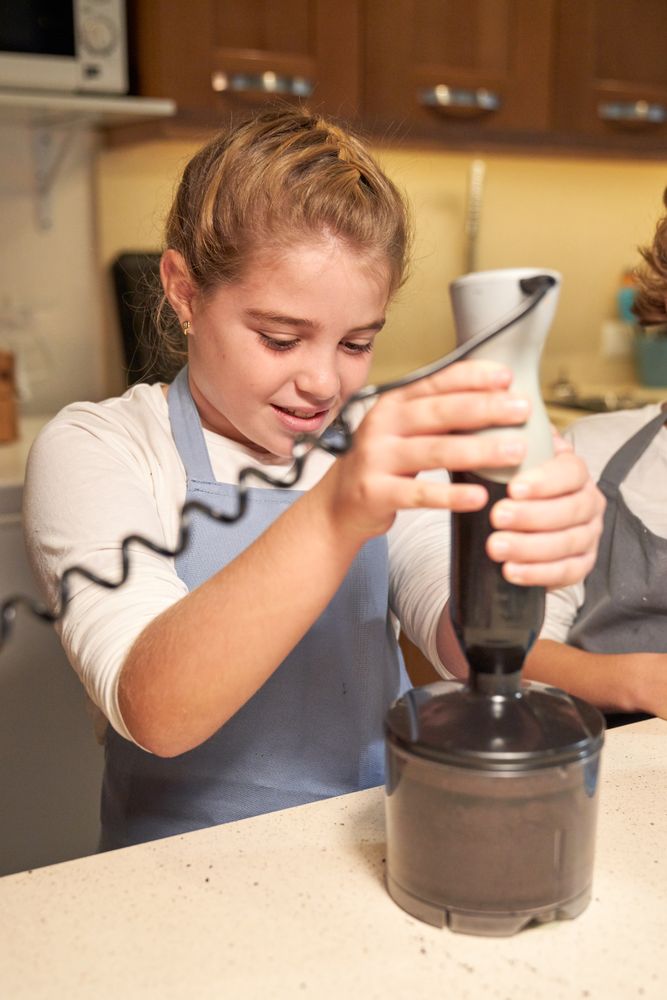 Girl grinding ingredients in blender