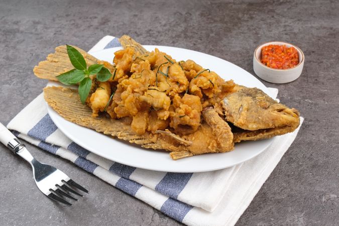 Gurame Saos Telur Asin. Crispy fried gourami fish covered with salted egg sauce. Indonesian food