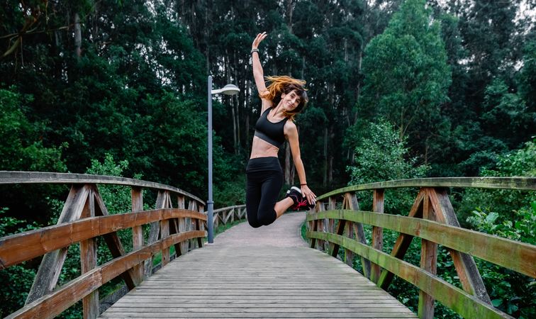 Happy athlete woman jumping outdoors