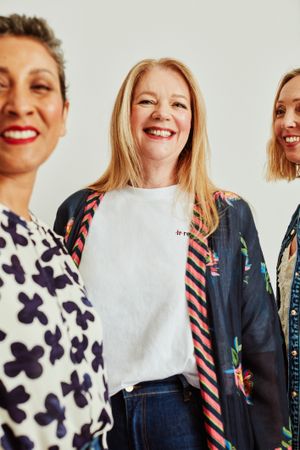 Three happy older women standing together in studio portrait