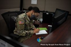 US female soldier with facemask working on desk 4Zwpnb