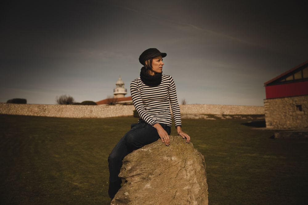 Woman and sitting on bench on shore near water