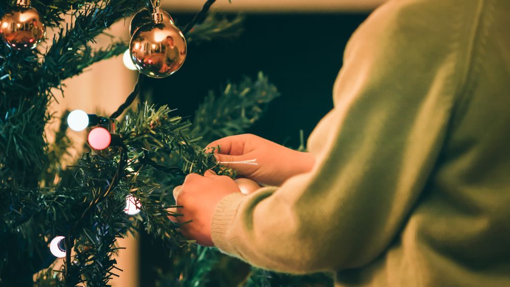 Boy decorating Christmas tree in evening
