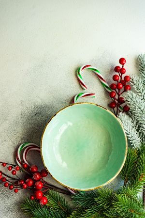 Top view of green wintry plate with candy cane and holly