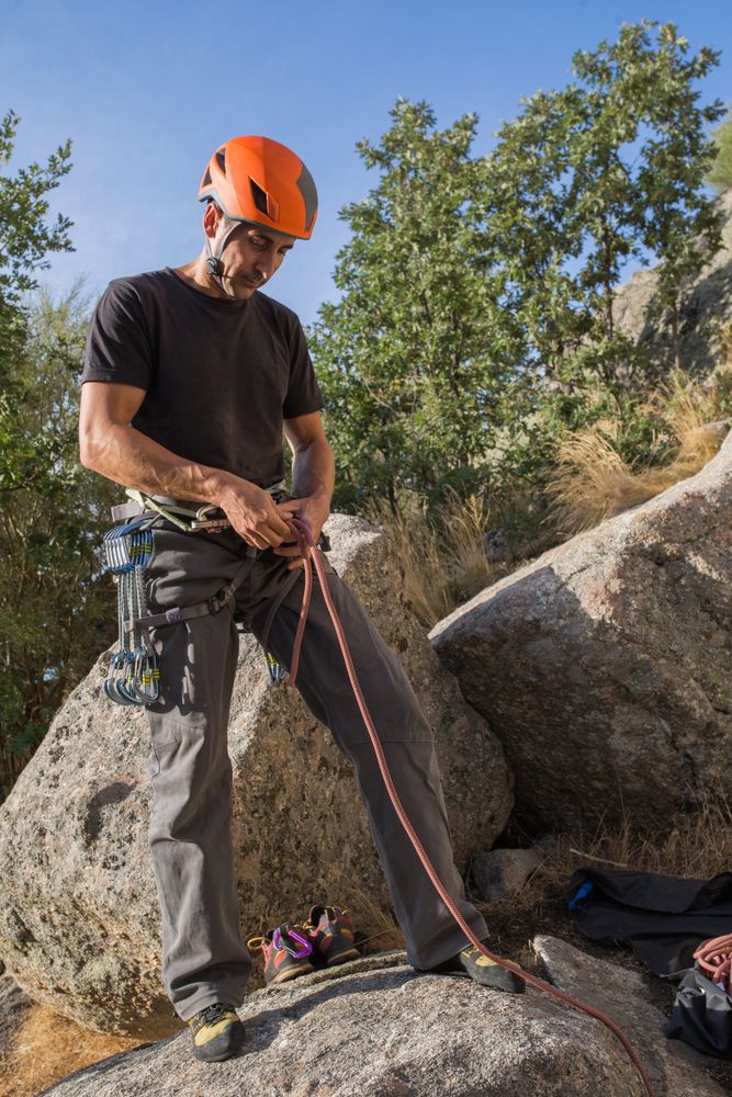A climber is preparing his ropes to start climbing