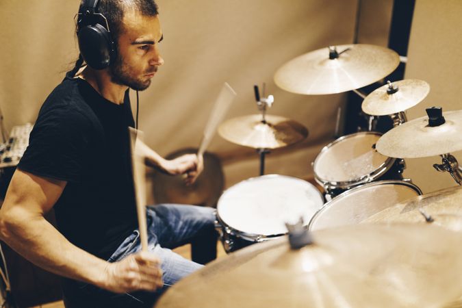 Man with headphones playing on drums