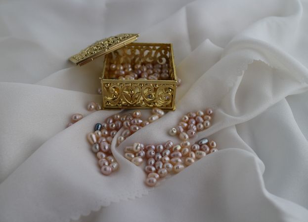 an open jewelry gold box with freshwater pearls