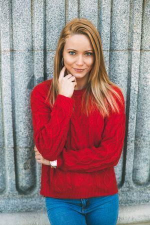 Stylish female standing near marble wall