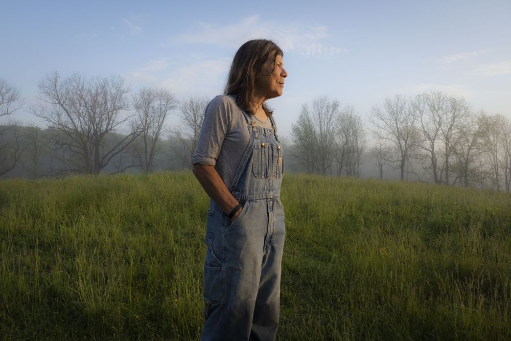 Shepherd Dominique Herman stands in a field on her farm
