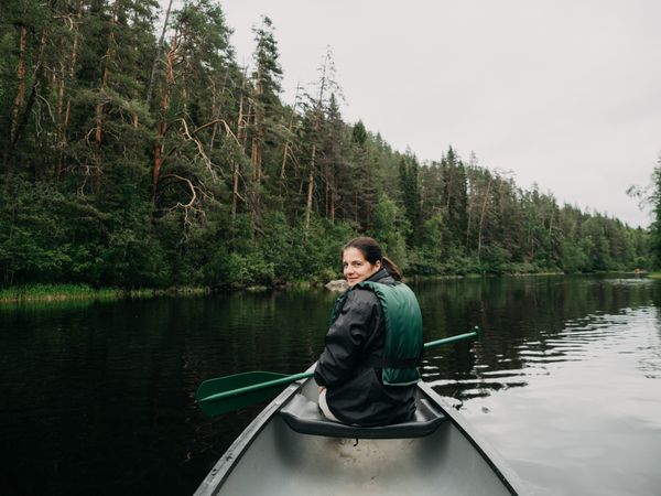 Woman boating on forest river in Finland