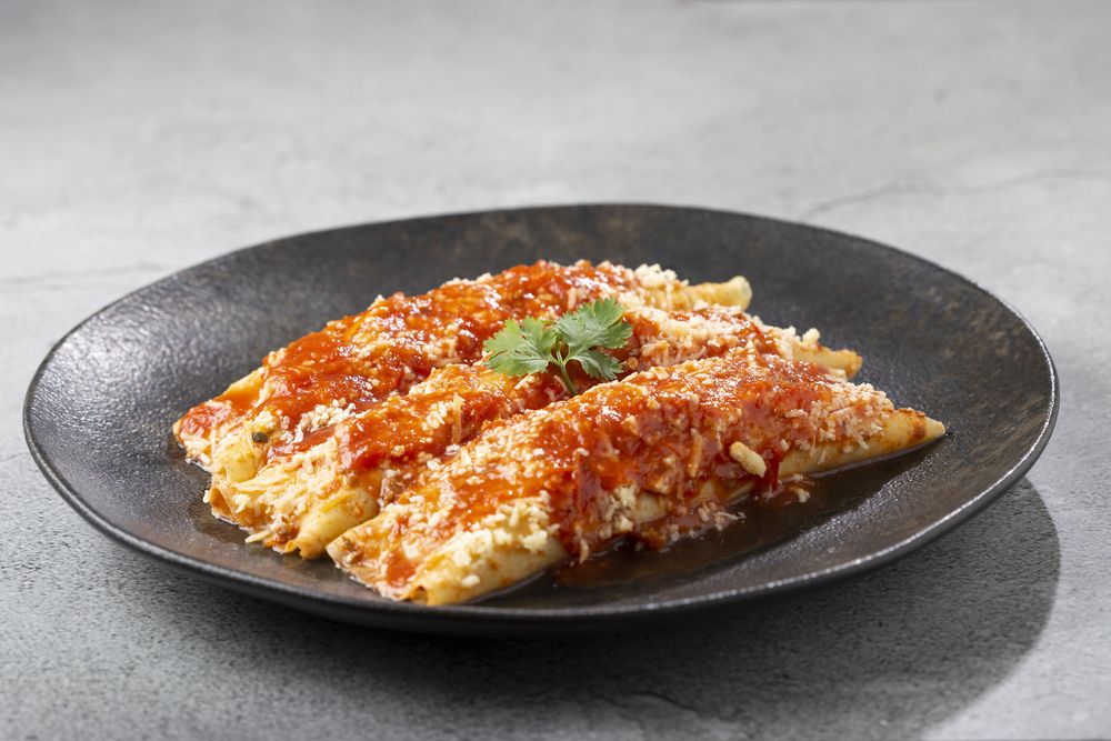 Pancakes stuffed with minced meat and topped with tomato sauce and grated cheese.