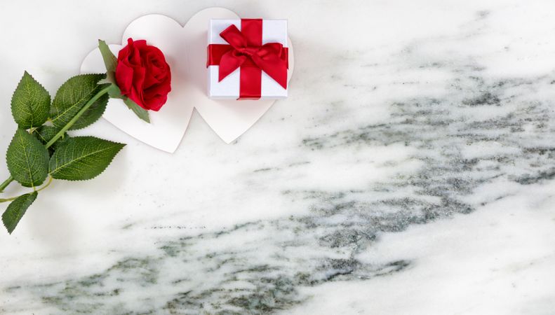 Valentine’s cards with lovely red rose and gift on marble