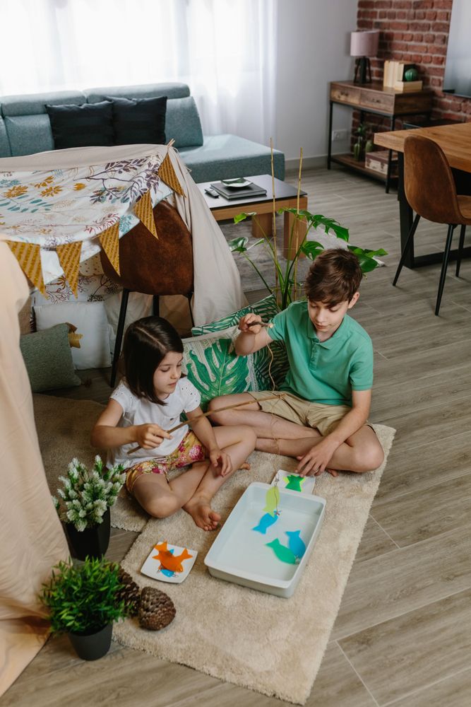 Children camping at home playing fishing game