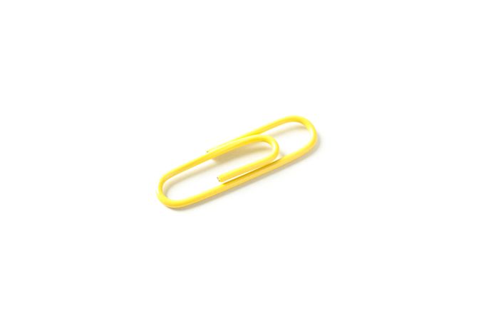 Color paper clip isolated on plain background, closeup