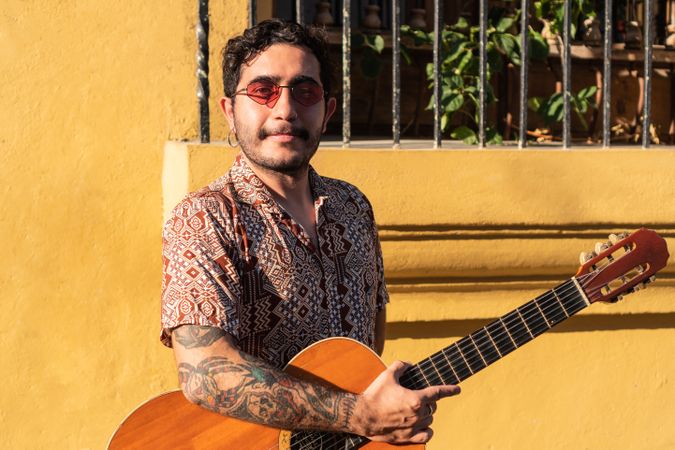 Portrait Of Young Musician With Acoustic Guitar Outdoors On The Street