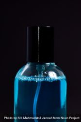 Close up of light blue perfume bottle in dark studio 0LdL9A