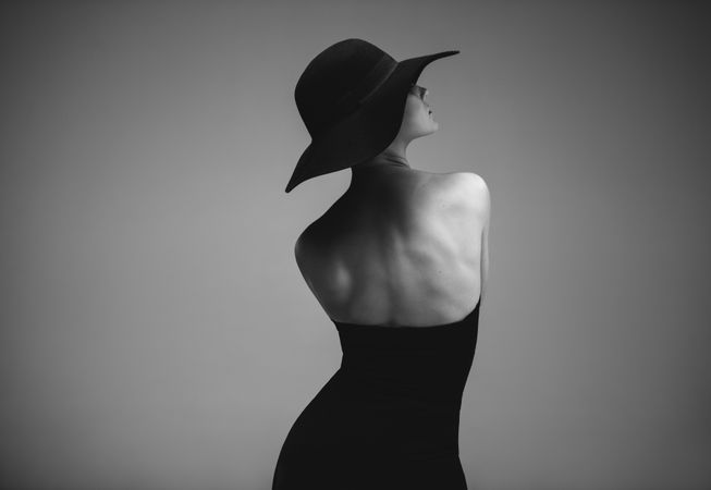 Elegant woman in dark dress and hat