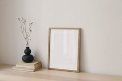 Table with modernist vase and decorative reeds and blank frame