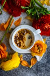 Summer floral card with top view of espresso surrounded by fresh flowers